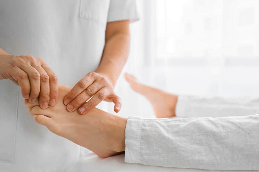 doctor examining foot joint