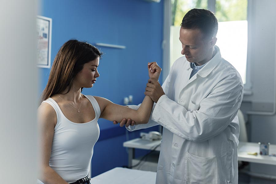 Médico examinando epicondilitis